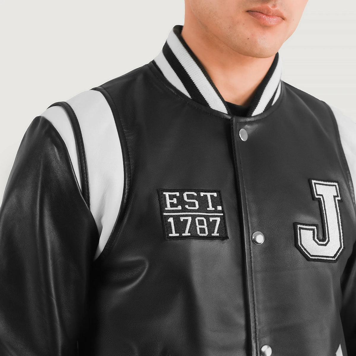 
Крупный план деталей of Varsity & Snap Button Hardware on Liberte New Jersey Черный Leather Varsity Кожаная куртка для Мужчин